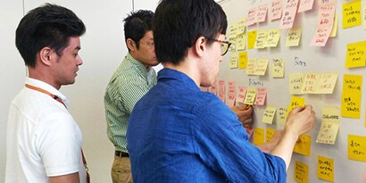 参加者はポスト・イット® 強粘着ノートに考えを書き出し、ホワイトボードには決定事項を記入する
